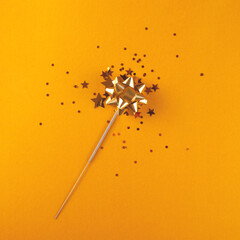 Sparkler concept in layout. New Year's sparkling sparkler made of stars, bows and sequins. Christmas festive background