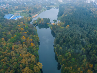 Obraz premium view from the bird's eye view of the beautiful river and colorful autumn forest on a cloudy day, the photo with the drone.