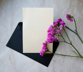 Greeting, post card, invitation card photo mock up on marble background with black envelope and decor.