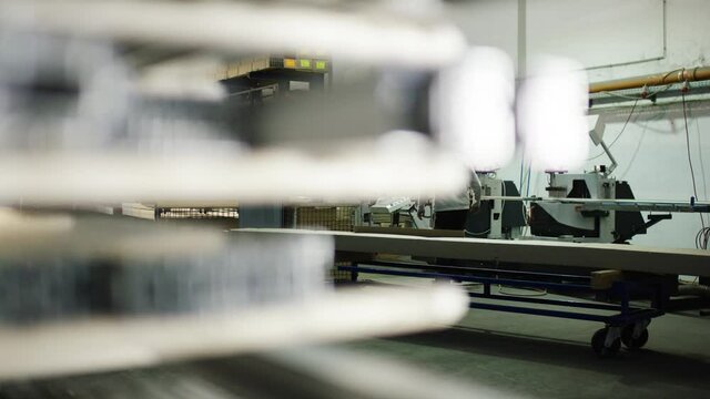 Person cutting metal profiles with buzzsaw in big warehouse/workshop 4k PRORES Footage