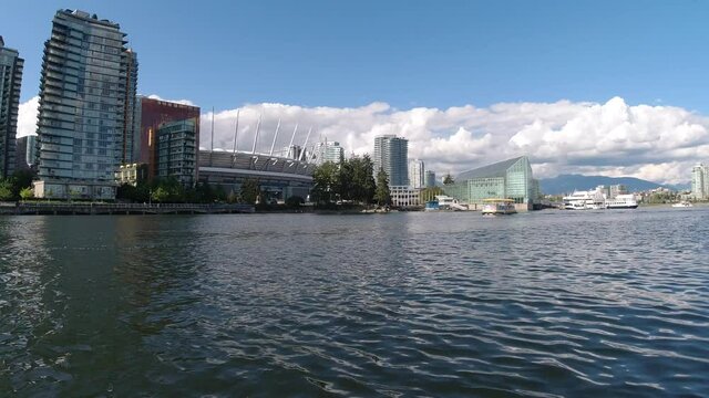 Aerial Low fly by 1 foot above sea level thru False Creek BC Vancouvers private yacht tour parking for the elite few next to expensive housing Hotel Parq, BC Stadium, Plaza of Nations pier port dock.