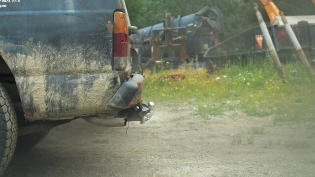 Dark smoke pollution coming out of exhaust of dirty old black truck on scrapyard