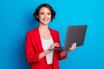 Portrait of attractive cheerful skilled businesslady holding in hand laptop isolated over bright...