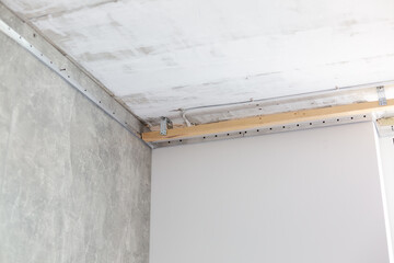 fix the metal frame for the stretch ceiling with an electric screwdriver. Repair, construction, DIY concept.