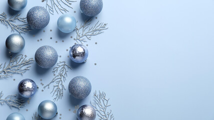 Christmas flat lay composition. Blue and silver balls , decorations, confetti on pastel blue background. Elegant, minimal style. Xmas greeting card template, banner mockup.