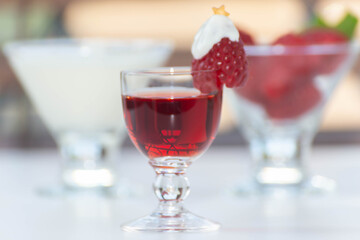 A festive red drink with a Christmas tree decoration made of raspberry and whipped cream