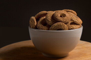 Ring Coconut biscuits served on a bowl. Brazilian little donut. Seletive focus in a front view and low light
