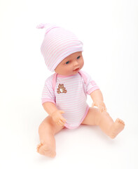 Toy baby doll in pink clothes and hat on white.
