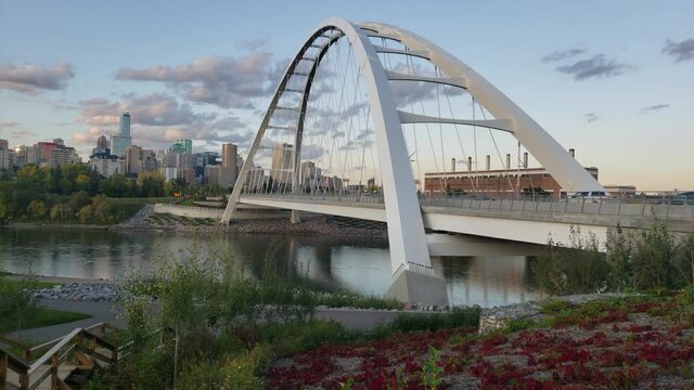 Walter Dale Modern Bridge bowstring designed by a Korean in Edmonton Alberta Canada. Side view where no people are walking by, vehicles headed downtown to the city core on an early evening.