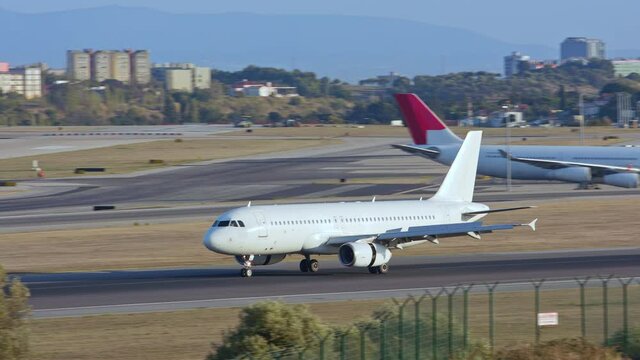 Generic Unmarked White Commercial Passenger Jet Airliner Arriving on Runway after Landing at an International Airport near Lisbon Portugal on a Sunny Day in Europe