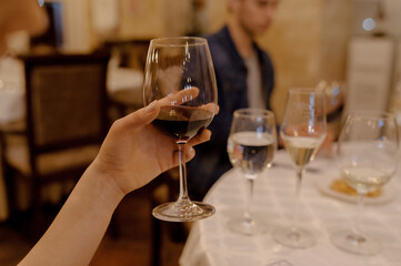 Wine tasting process. Woman with a glass of red wine.
