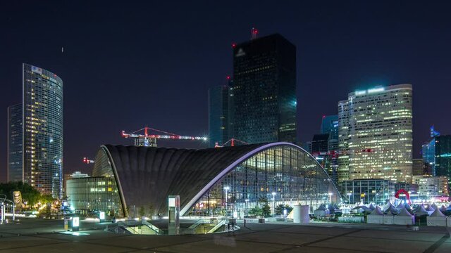 Unique illuminated skyscraper at night timelapse in famous financial and business district of Paris - La Defense. View from Grand Arch