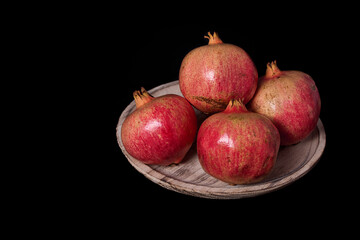 Pomegranates on wooden plate