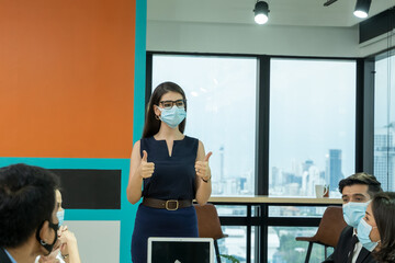 Business woman wear protective masks prevent PM 2.5 and corona virus leads meeting  in modern bright office interior brainstorming.