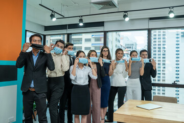 Group of business people standing in the office with face mask protect from Corona virus,Concept of help,Support and collaboration together to overcome pandemic of Coronavirus to reopen business.