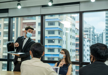 Group of business people with face mask protect from Coronavirus or COVID-19 having meeting together.