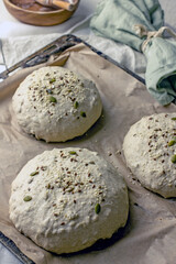 Yeast-free bread dough formed into baking loaves on a baking sheet. The process of making natural homemade sourdough bread with your own hands.Self-made bread at home