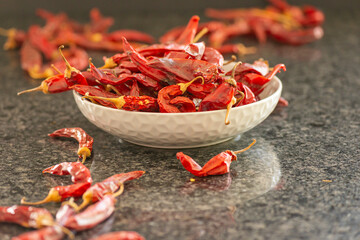 Dried red chili or chilli cayenne pepper on black marble background, close up