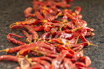 Dried red chili or chilli cayenne pepper on black marble background, close up, selective focus