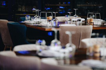 tableware Glasses, flower fork, knife served for dinner in restaurant with cozy interior