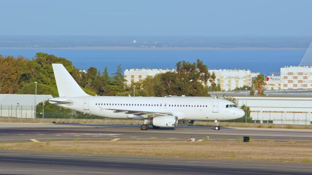 Generic Unmarked White Commercial Passenger Jet Airliner Taxiing on Taxiway near Runway at an International Airport near Lisbon Portugal on a Sunny Day in Europe