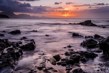 Fototapeta na wymiar Waves and sunset at the coastline of Fuerteventura