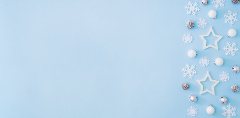 Flat lay border with christmas balls and snowflakes on a blue background