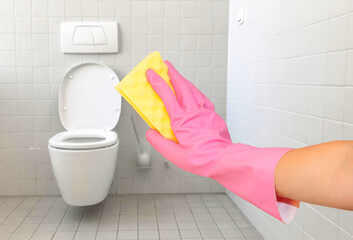hands in pink gloves clean the toilet