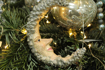 Old Christmas toy Month on the background of balls and spruce branches, close-up