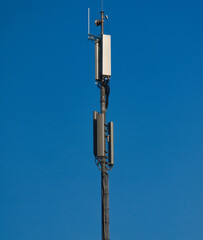 A GSM antenna on a sky blue background - 388614725