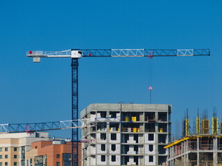 A crane constructing new concrete buildings in the city - 388614756