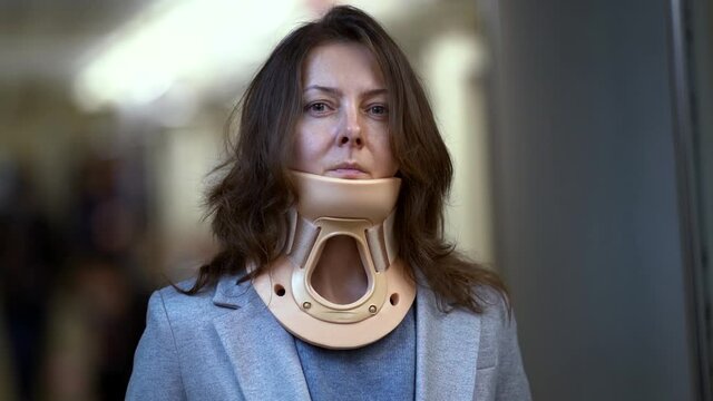 portrait of adult woman with medical neck brace for curing neck injury or osteochondrosis problem, contemporary sedentary lifestyle