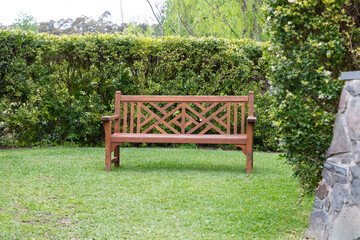 A wooden bench on grass in a large garden