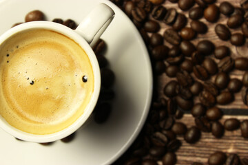 Cup of espresso coffee with scattered coffee beans with space for text. Poster.