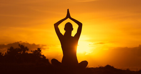 silhouette of a person meditating in the sunset