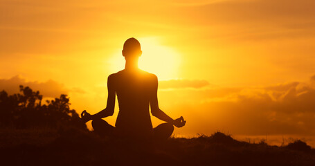 silhouette of a person meditating in the sunset