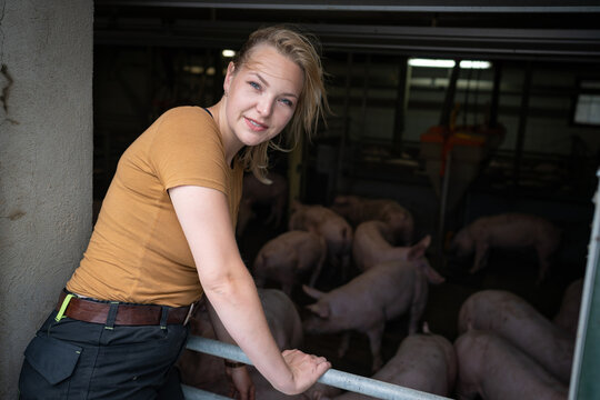 Bäuerliche Landwirtschaft, junge Landwirtin vor einer Mastschweinebucht - Symbolfoto