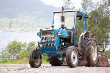 charming blue tractor in the field with dents and wear