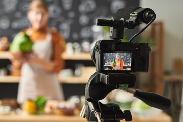 Young woman holding vegetable and recording the video about food for her blog