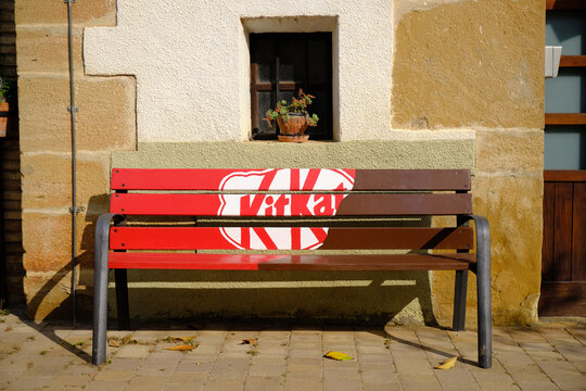 Bench with KitKat advertising on sunny day.  Arre, Spain. June 14, 2019