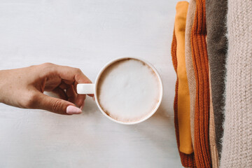 A Cup of coffee and a stack of warm sweaters