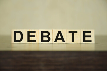 Obraz premium the word debate is written on wooden cubes that lie on a black table