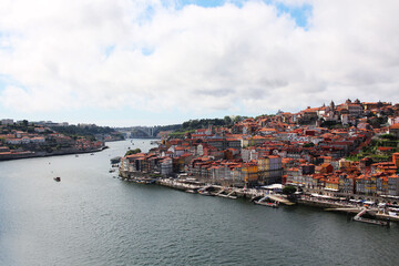 Fototapeta na wymiar Portuguese city of Porto, view from the waterfront. Houses and a river with ships and boats