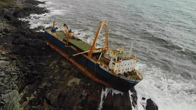 Old Shipswreck stranded on a rocky Beach. Abandoned Ghost Ship Aerial