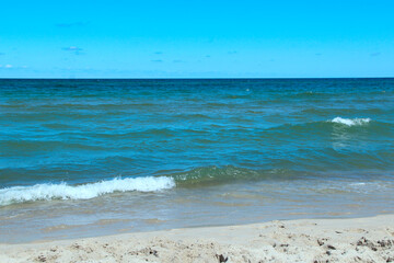 Beautiful ocean waves on sandy beach. Splashing sea wave. Vacation concept