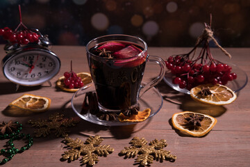 A Cup of fragrant mulled wine with spices, decorations for the New year, a branch of berries on a...