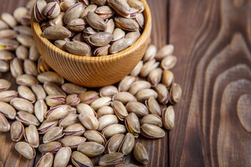 Pistachios in a Cup on a wooden background.  Place for text. Nuts close up