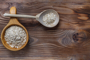 Wooden Cup and spoon with oatmeal. The concept of healthy eating. Wood texture. Flat layout. Copy space