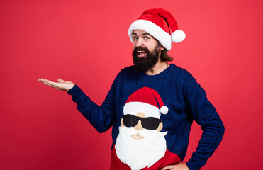 Fototapeta na wymiar happy bearded man in santa claus costume celebrate winter holiday of chistmas and feel merry about xmas gifts, presenting product