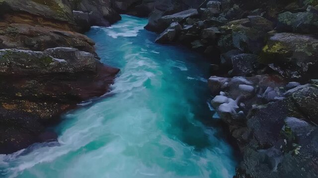 Ice cold glacial water moving through the frozen cliffs and down river. 4K video